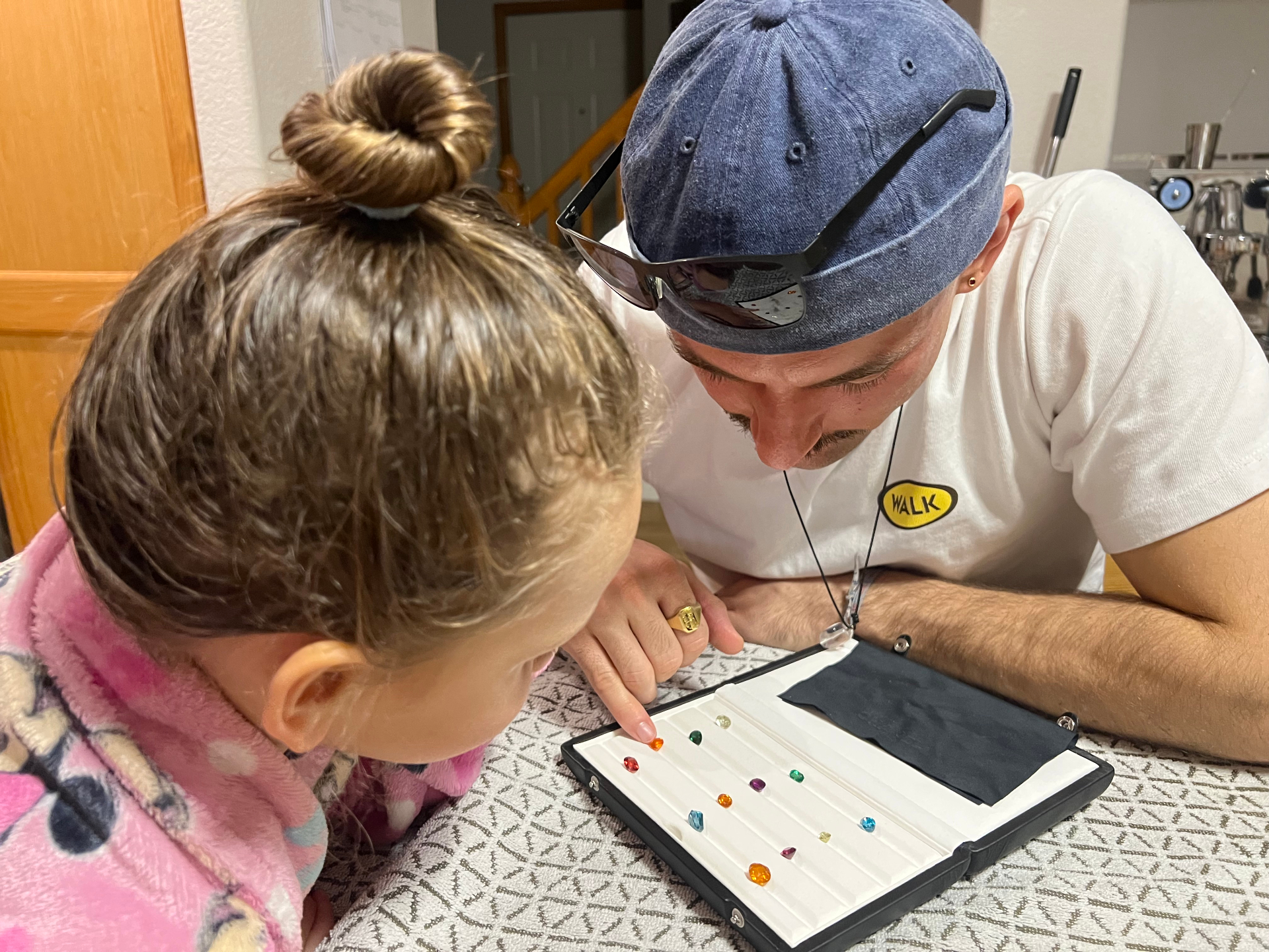 Dayne showing a gemstone tray during a family consultation moment at the table