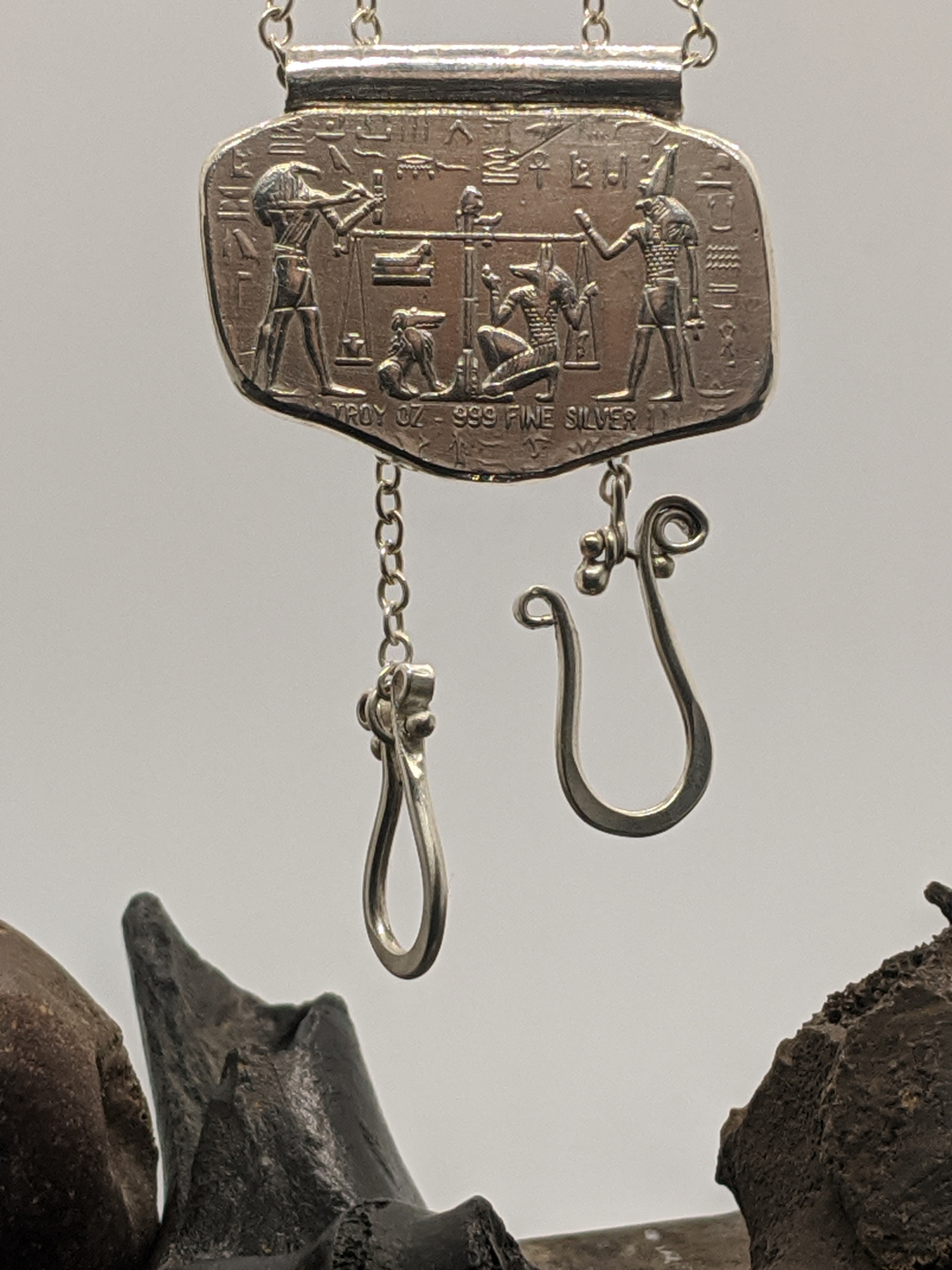 Early sterling silver pendant with Egyptian-inspired relief and suspended wire drops