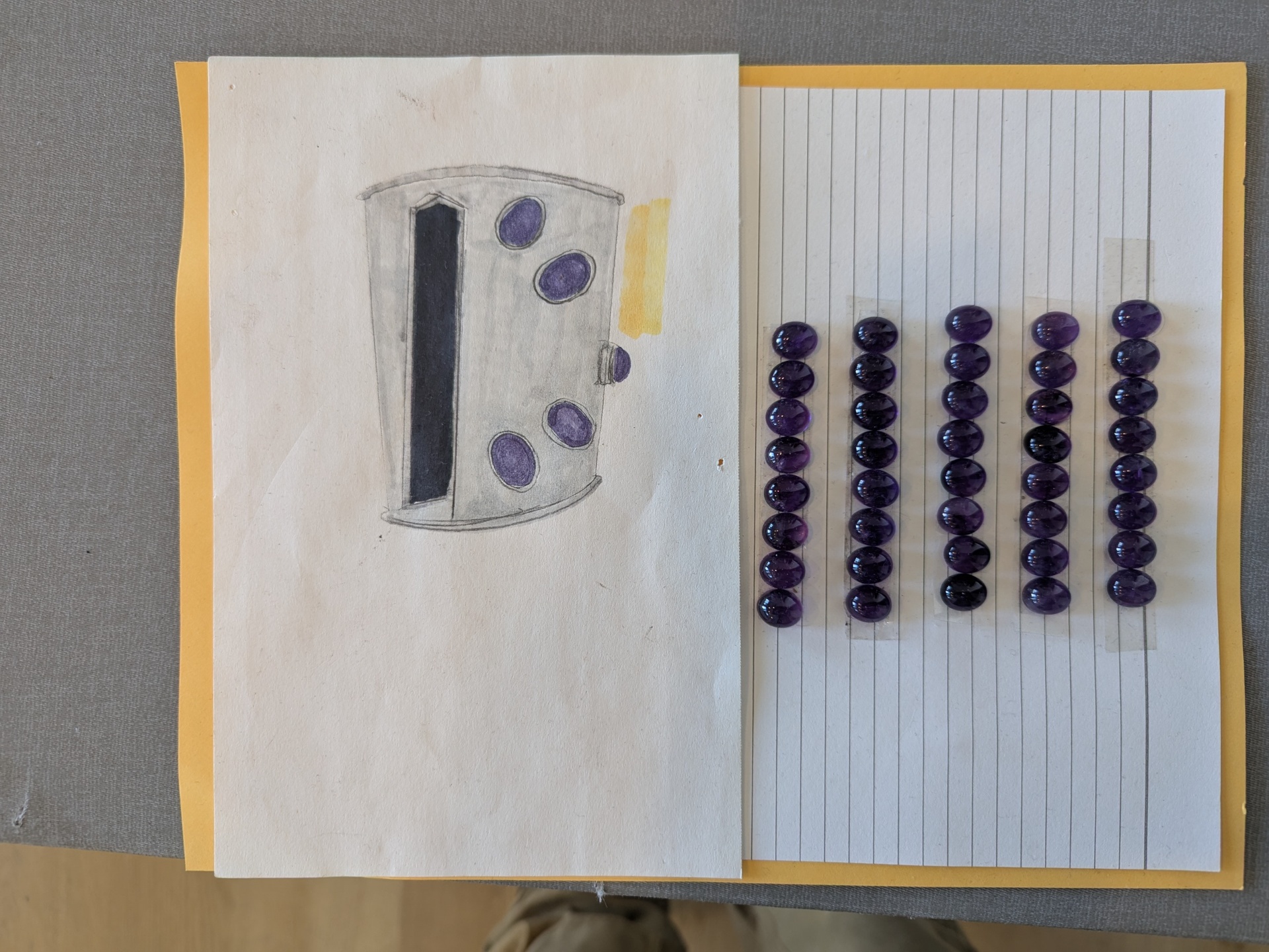Amethyst cabochon cuff study alongside rows of loose purple amethyst stones