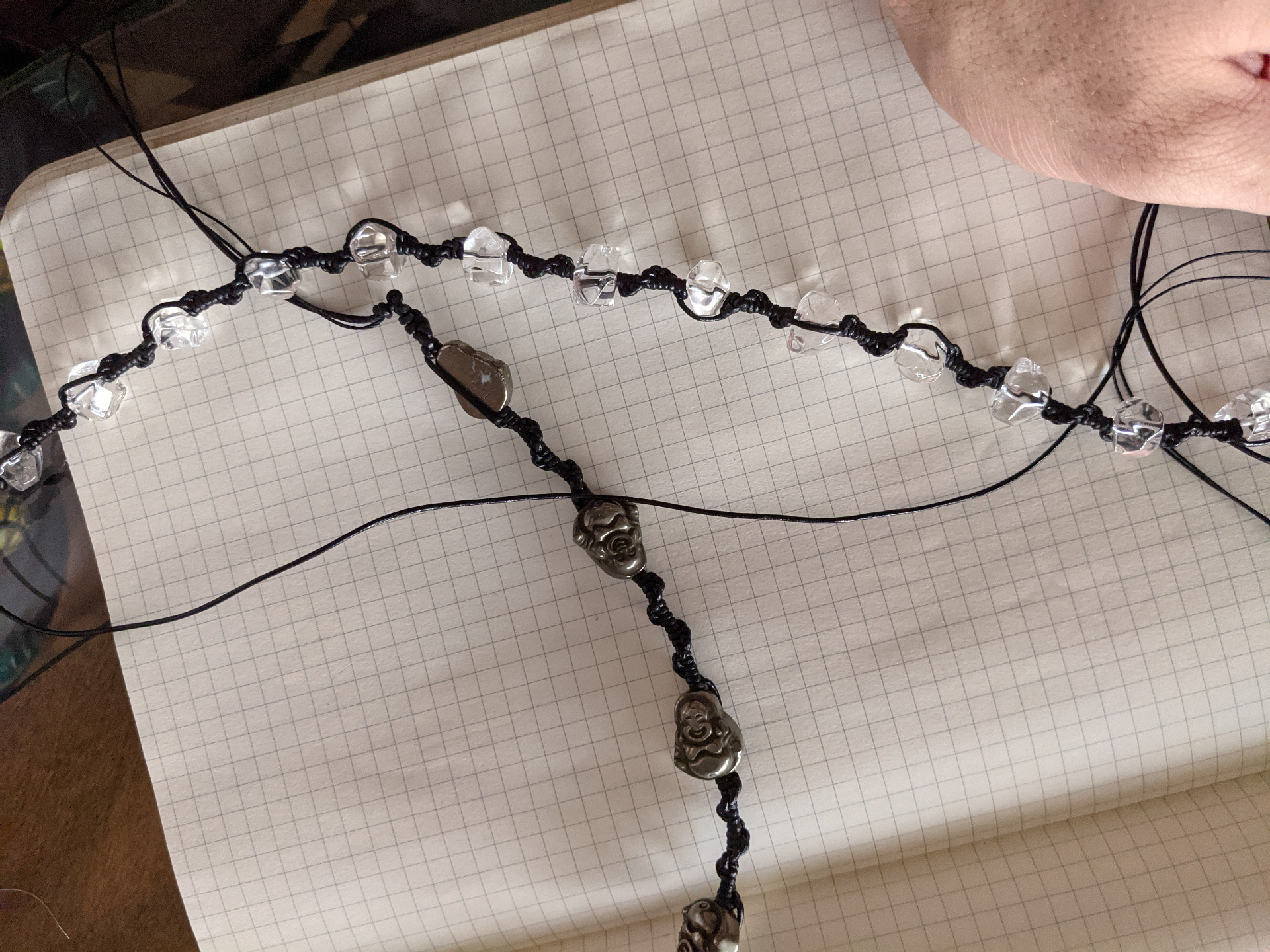 Macramé necklace in progress with clear quartz beads and pyrite Buddha pendants