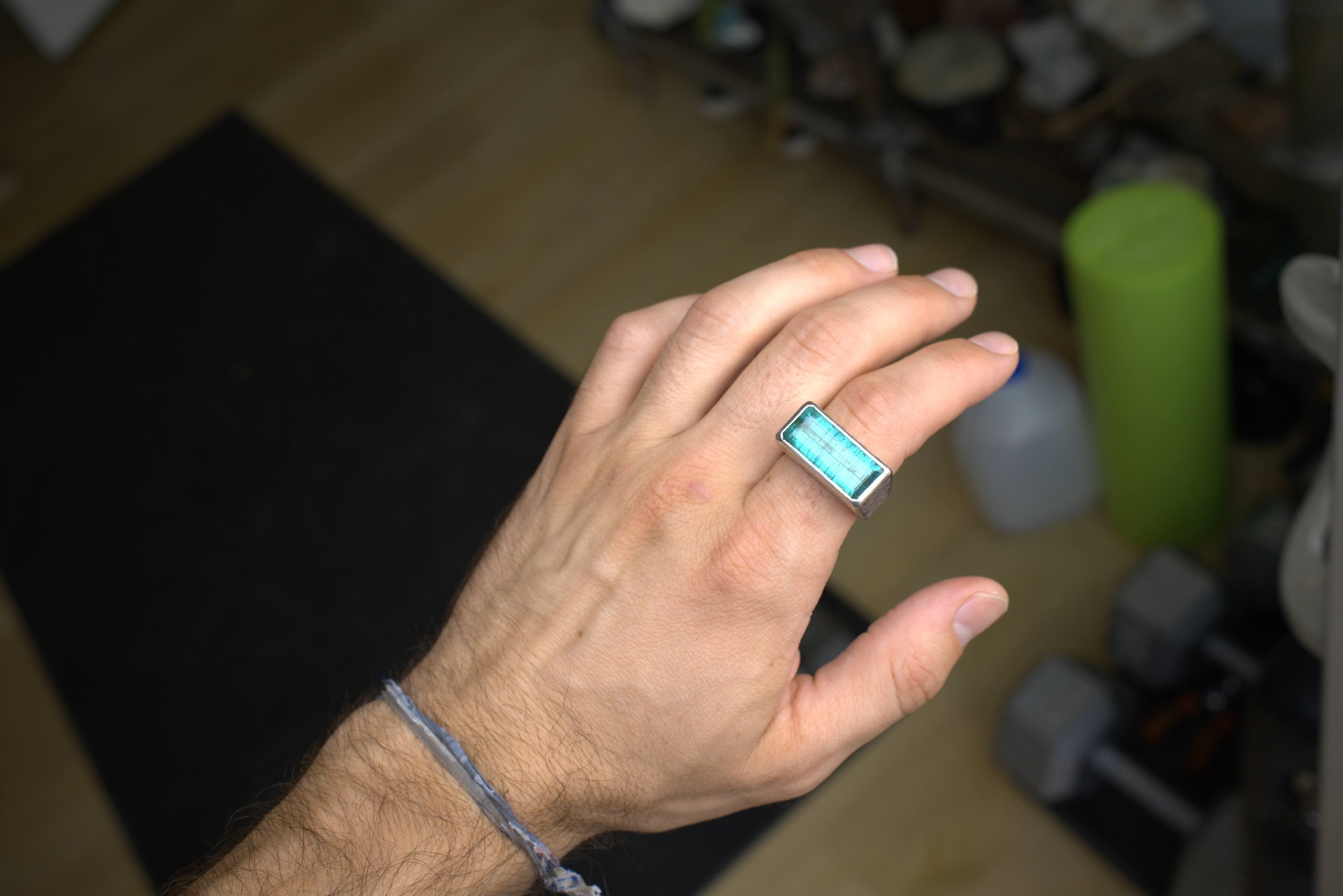 Sterling silver bar ring with an emerald-cut indicolite blue tourmaline center stone worn on hand