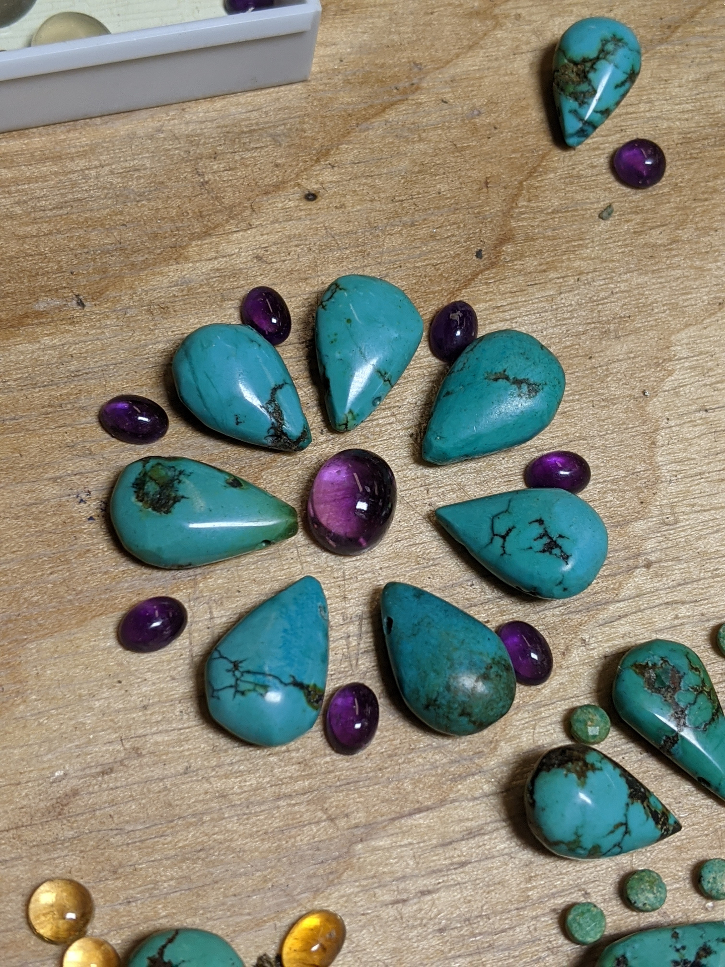 Hand-cut turquoise teardrops arranged with amethyst cabochons in a flower layout
