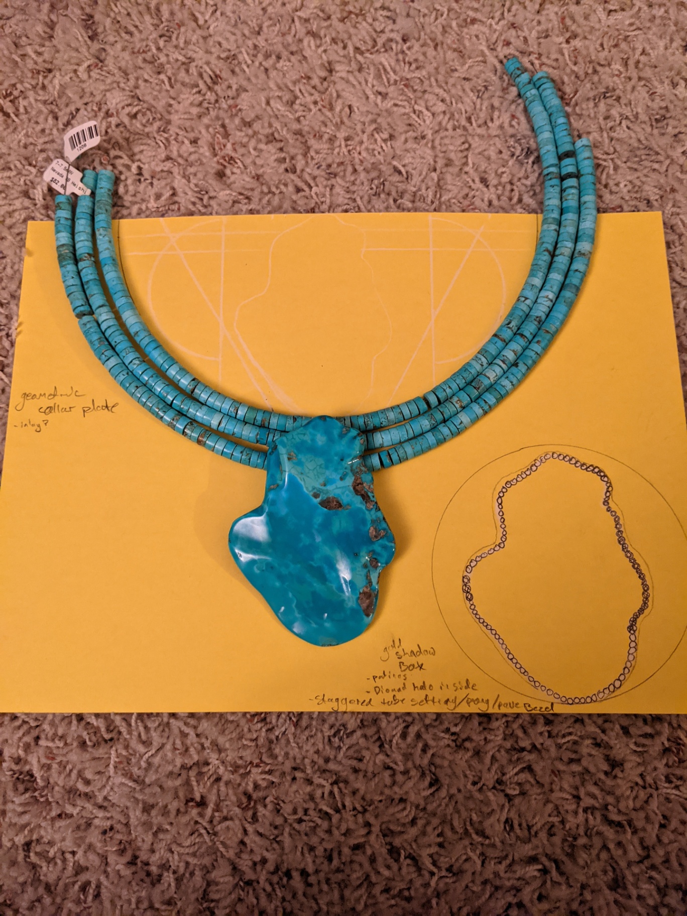 Turquoise heishi strands with a large turquoise slab pendant on a yellow design board